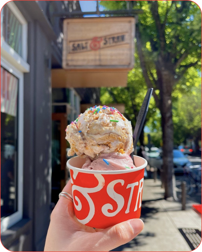 holding ice cream in front of salt and straw sign